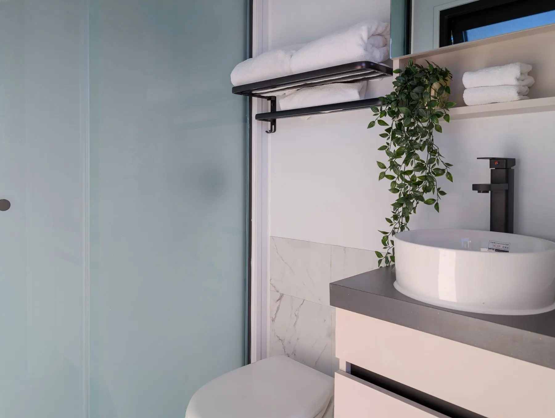 The pavilion bathroom: shower, basin and folded towels