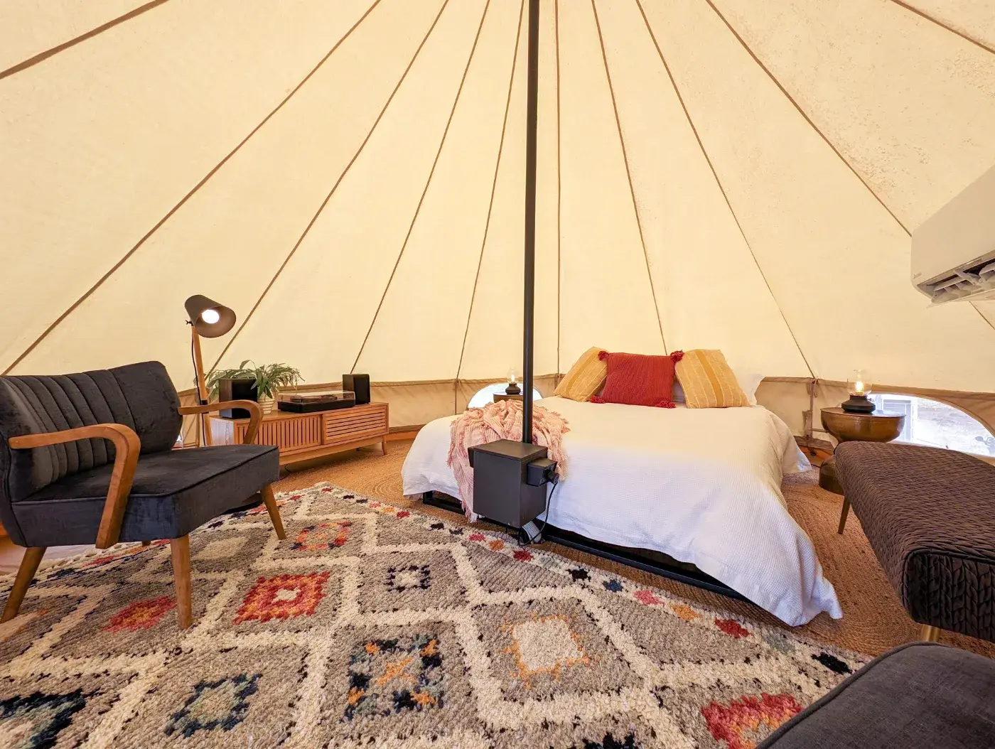 Inside the Bell Tent, queen bed made up with a record player