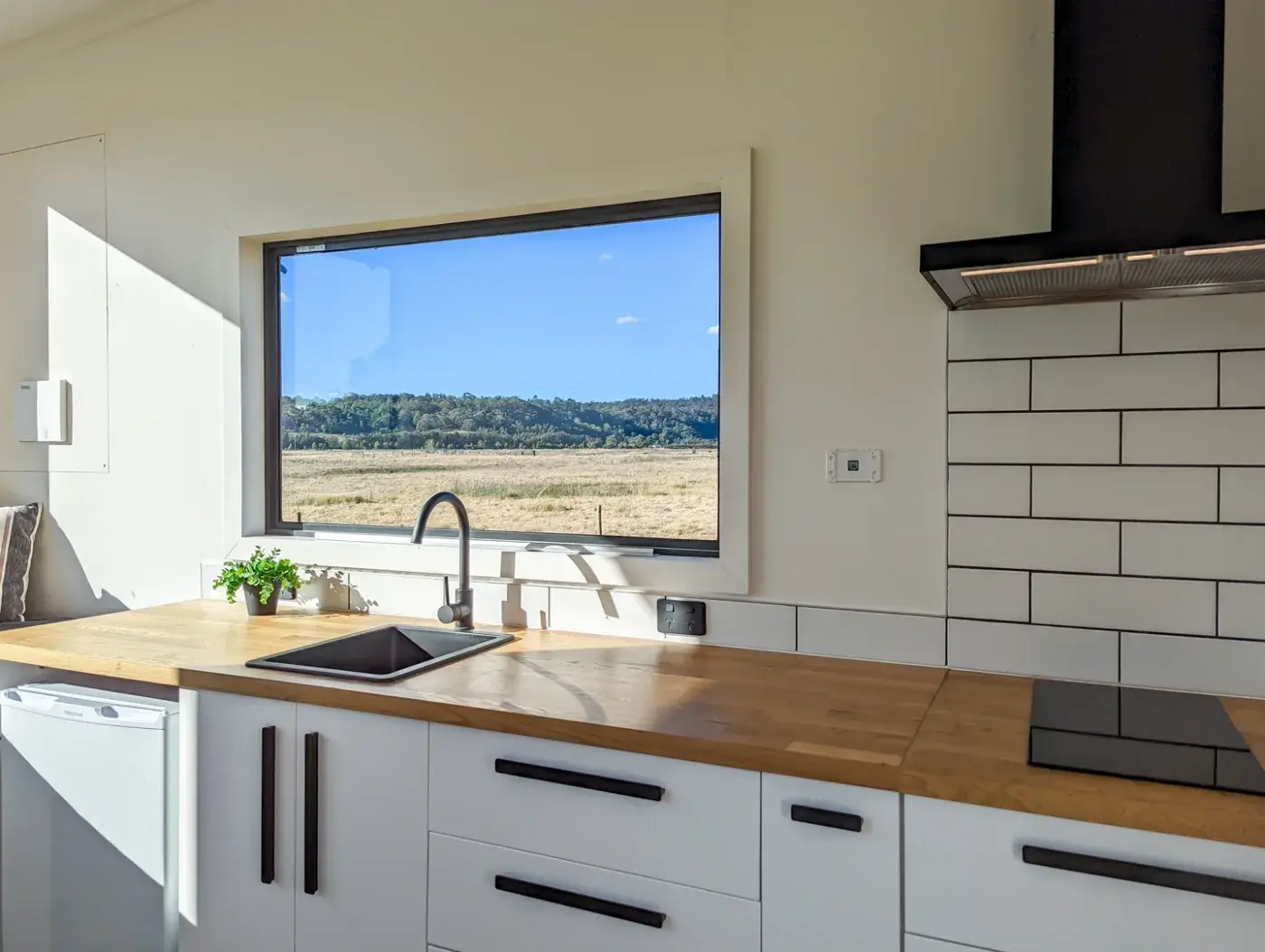The pod kitchen bench with the paddocks through the window