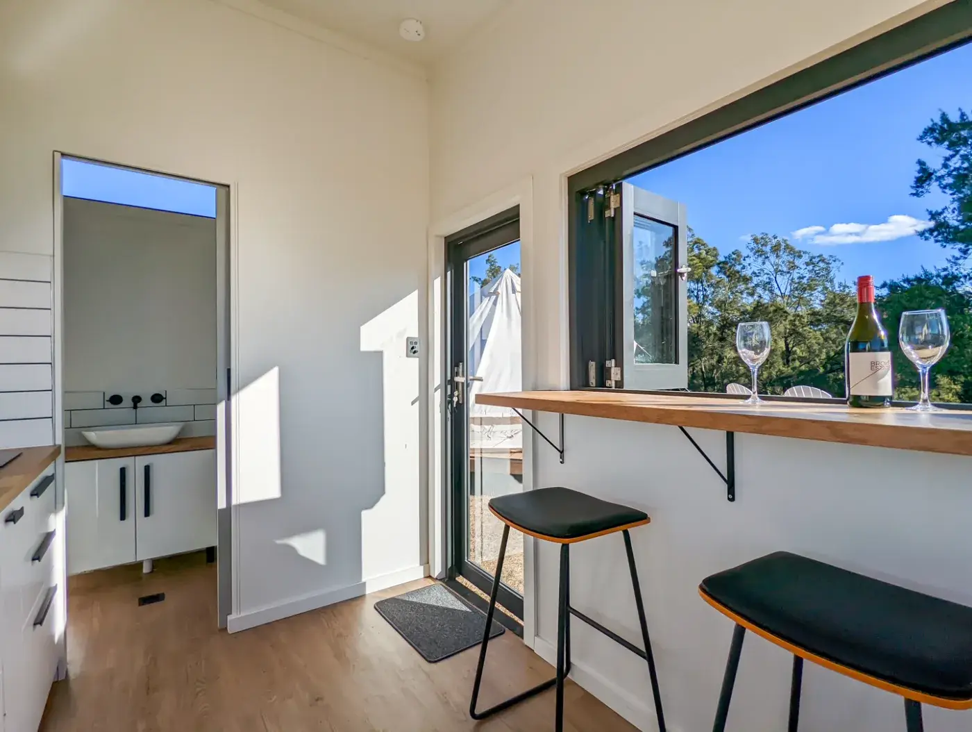 Inside the pod, the bar bench by the window and the bathroom through the door
