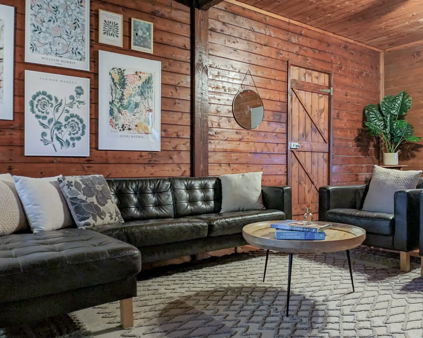 The other end of the Cottage living room, deep leather sofas and framed prints